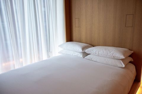 Minimalist bedroom with wooden headboard and white linens