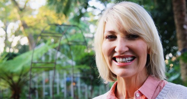 Smiling mature woman outdoors in lush green garden - Download Free Stock Images Pikwizard.com