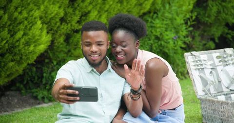 Smiling Couple Taking Selfie in Outdoor Garden Setting