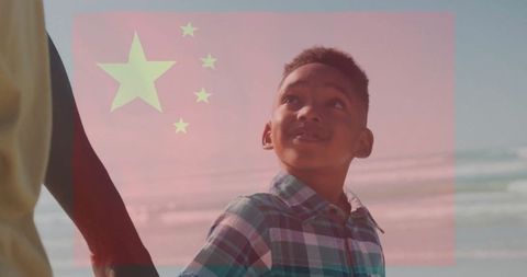 Father and Son Holding Hands on Beach with Red Star Overlay