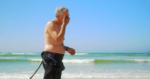 Senior Surfer Applying Sunscreen on Beach