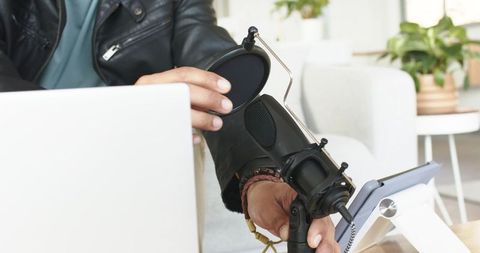 Mid adult man adjusting microphone pop filter for podcast recording at home studio