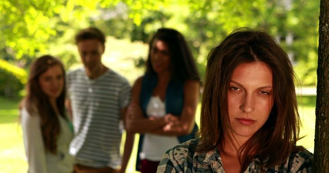 Young Woman Upset in Park with Concerned Friends in Background - Download Free Stock Images Pikwizard.com