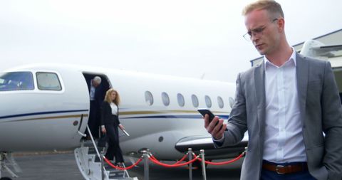 Business Professional Checking Mobile Phone at Airport - Download Free Stock Images Pikwizard.com