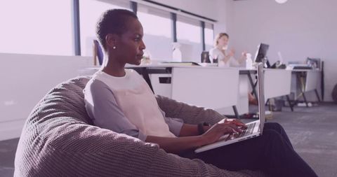 Focused Woman Working on Laptop in Modern Open-Plan Office
