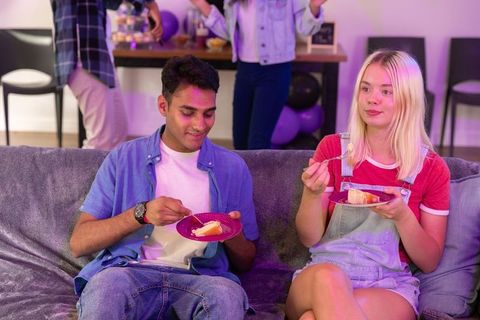 Young friends celebrating and eating cake in cozy home gathering