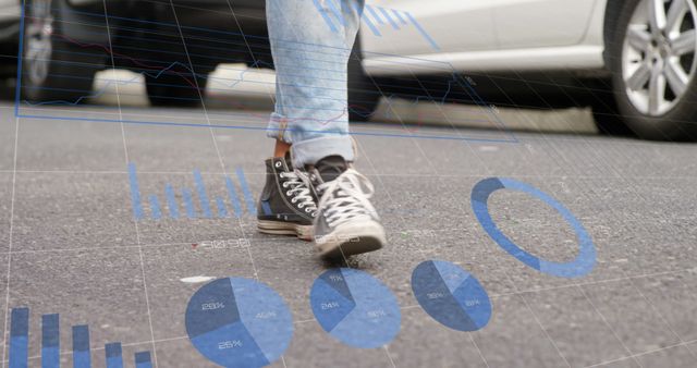 Graphs and data processing on interface screen over low section of person walking in road. City, urban lifestyle, communication and digital interface technology digitally generated image.