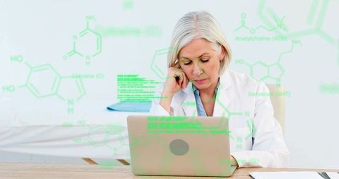 Senior female doctor analyzing digital medical data on laptop with chemical formulas