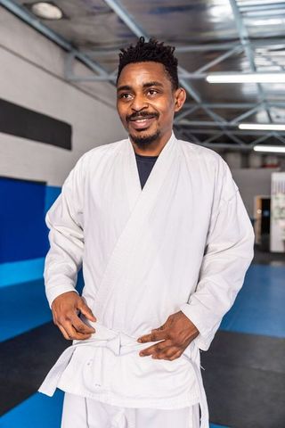 Martial Artist Tying White Belt in Training Studio