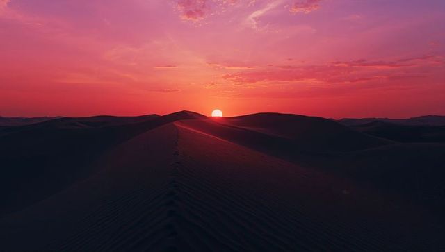 Vibrant Sunset in Desert with Pink Dunes and Setting Sun
