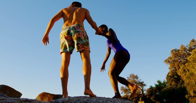 Couple Hiking on Rocky Cliff at Sunset - Download Free Stock Images Pikwizard.com