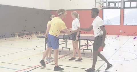 Table tennis players shaking hands after match in school gym showing sportsmanship