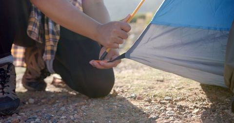 Woman Securing Tent Pole for Mountain Camping Adventure