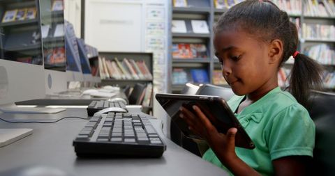Focused Schoolgirl Engaging Tablet in School Library Environment - Download Free Stock Images Pikwizard.com