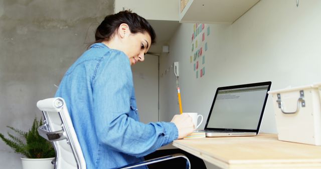 Woman Working Remotely From Home Office, Using Laptop And Taking Notes - Download Free Stock Images Pikwizard.com