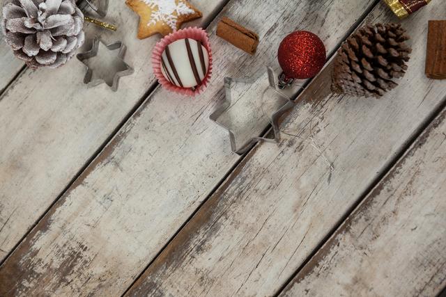 Christmas cookie cutters and festive decorations arranged on a rustic wooden table. Ideal for holiday-themed projects, baking blogs, festive greeting cards, and seasonal marketing materials.