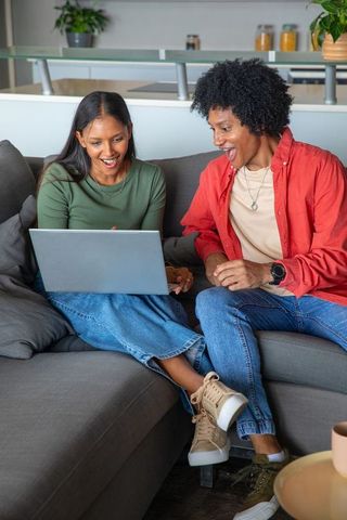 Diverse Friends Celebrating Success on Laptop at Home