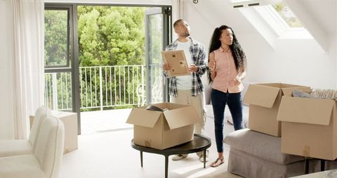 Couple unboxing in sunlit room of new home