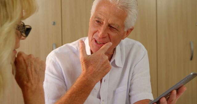 Elderly Man Sharing Digital Tablet with Senior Woman in Conversation - Download Free Stock Images Pikwizard.com