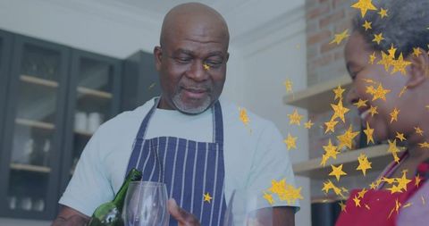 Couple pouring wine at kitchen countertop with gold stars celebrating intimate dinner