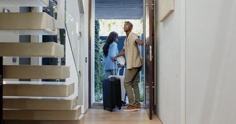 Friends arriving home traveling with suitcases in modern interior