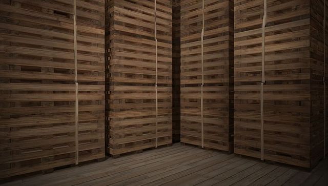 Filling warehouse corner with stacked wooden crates and strapped pallets on plank floor