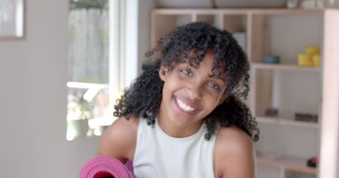 Cheerful Teenage Girl Holding Yoga Mat Indoors