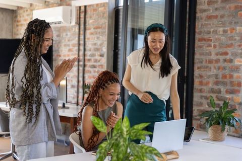 Diverse Female Coworkers Celebrating Success in Modern Office
