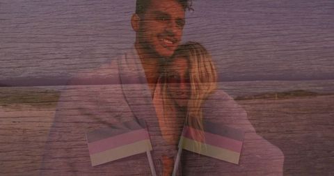 Romantic Couple Holding Flags at Twilight on Beach