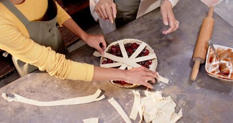 Mother and daughter creating lattice top in rustic kitchen
