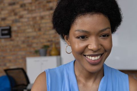 Confident Professional Woman Smiling in Modern Office Setting