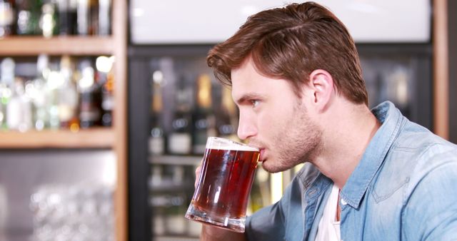 Casual handsome man drinking beer at bar