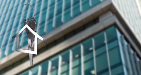 House Key with Fob in Front of Modern Glass Building