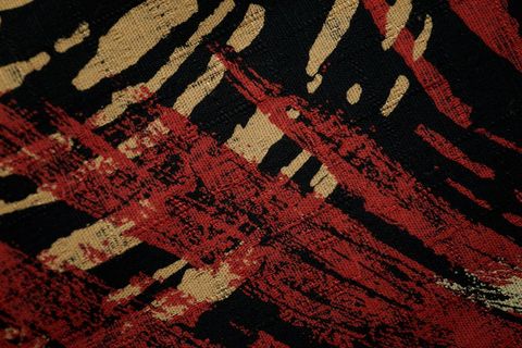 Featuring red and beige brushstroke pattern on black woven textile for abstract design