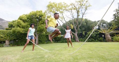 Family Enjoying Jump Rope in Sunny Garden