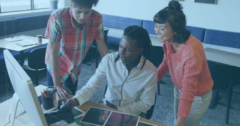 Team collaborating in creative workspace reviewing photos