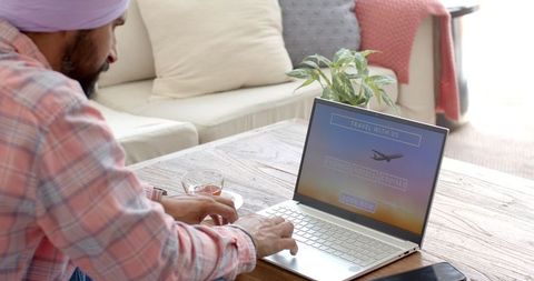 Man booking travel online from home environment