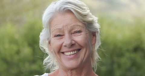 Smiling senior woman enjoying peaceful garden sunlight closeup with natural warmth
