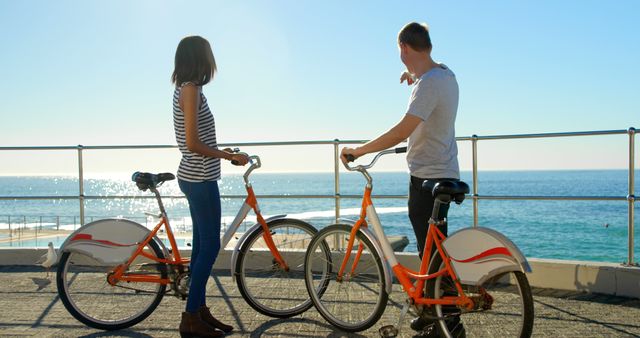 Couple Enjoying Bike Ride Along Oceanfront Promenade - Download Free Stock Images Pikwizard.com