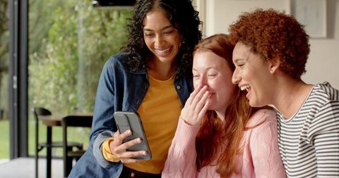 Diverse Female Friends Laughing While Viewing Smartphone