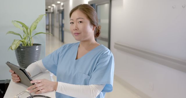 Confident Nurse Holding Tablet in Hospital Corridor - Download Free Stock Images Pikwizard.com