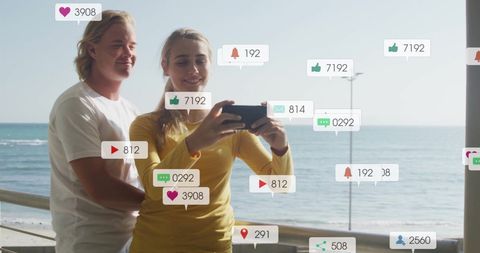 Smiling Couple Seaside Selfie with Animated Social Media Icons