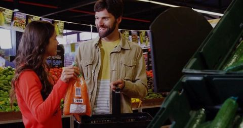 Couple Grocery Shopping Picking Fresh Carrots in Market