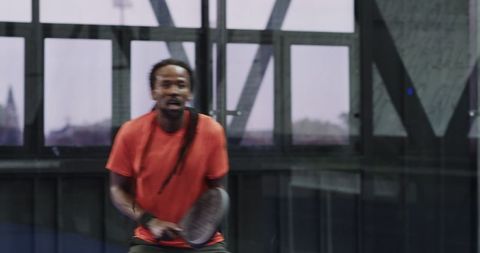 Athletic man playing paddle on urban recreation court