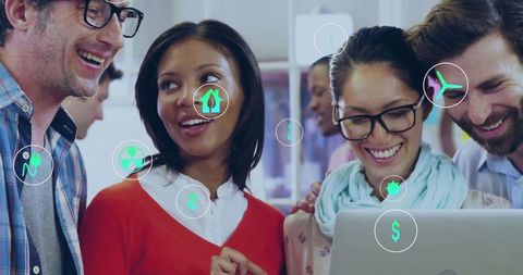 Diverse team collaborating over laptop with digital icons for innovation and teamwork