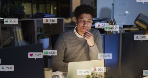 Man Analyzing Reports on Laptop with Social Media Notifications