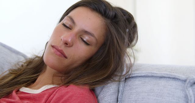 Young woman resting on sofa wearing red shirt - Download Free Stock Images Pikwizard.com