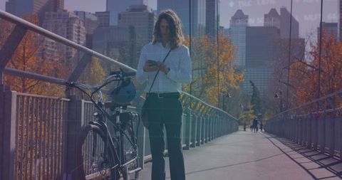 Businessman with Bicycle Using Smartphone on City Bridge