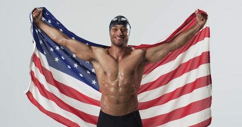 Triumphant swimmer draped in american flag celebrating achievement