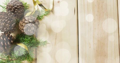Rustic Holiday Flatlay with Pinecones, Fir Sprigs and Gold Ribbon on Light Wood Planks